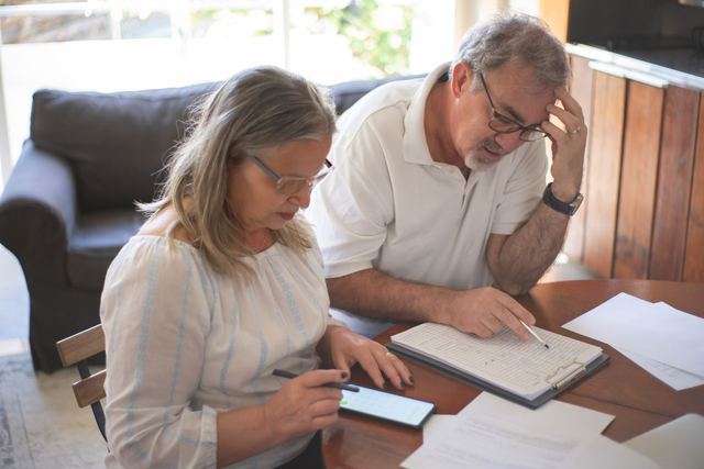 A couple reviewing papers at home
