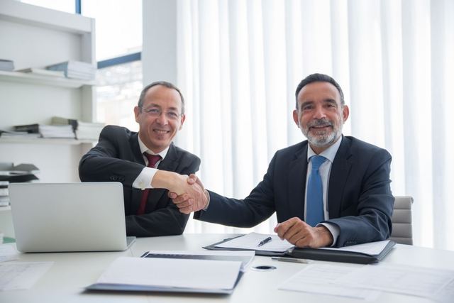 Two businessmen shaking hands over a deal